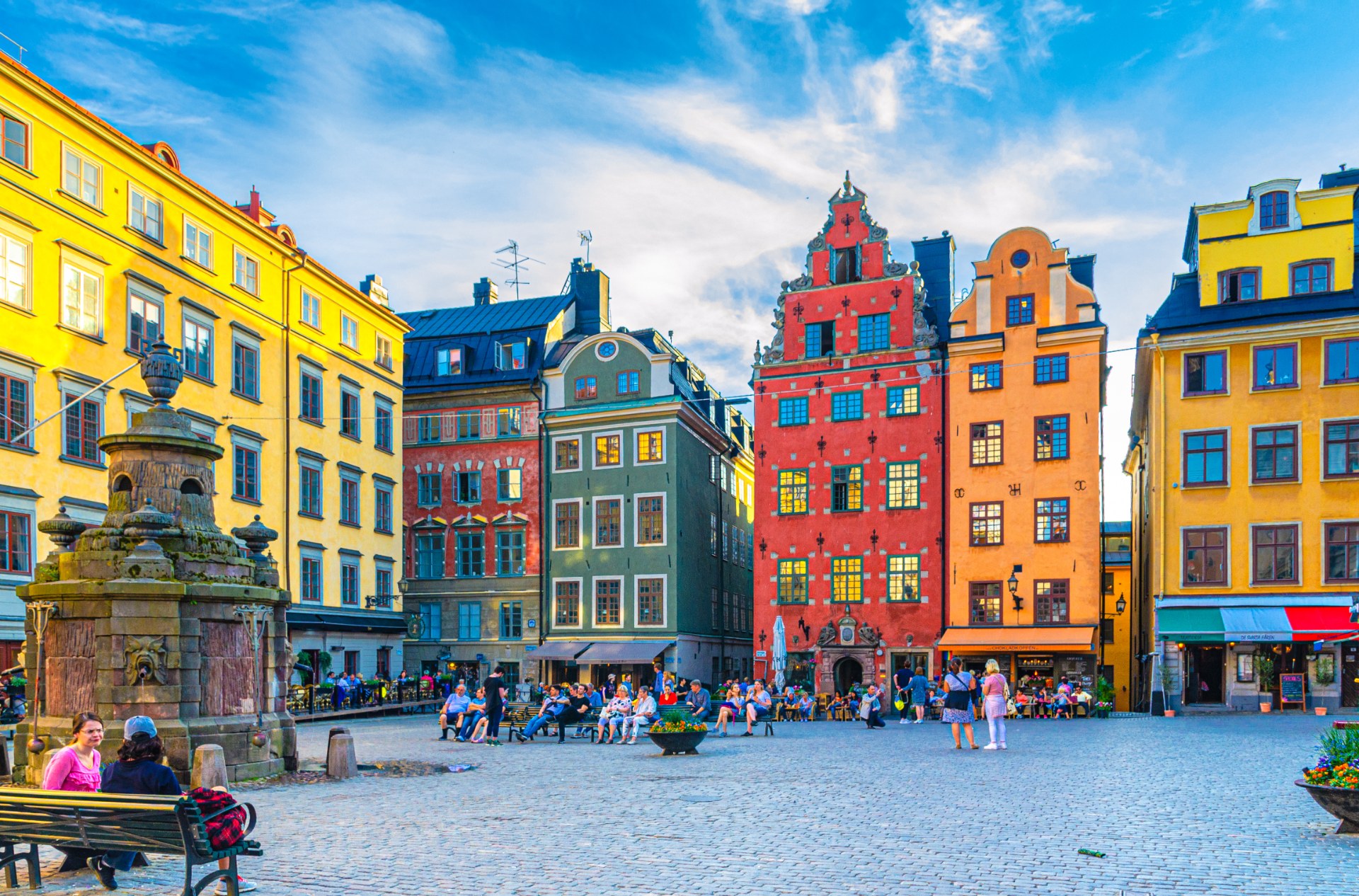 سياح ومارّة في ساحة Stortorget في ستوكهولم بين المنازل الملوّنة